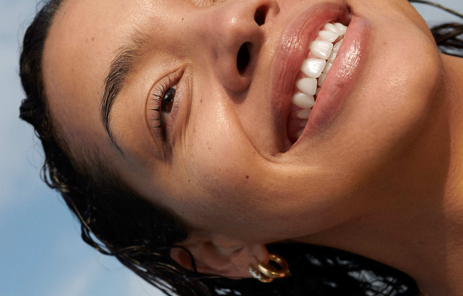 Close-up of smiling woman with wet dark hair