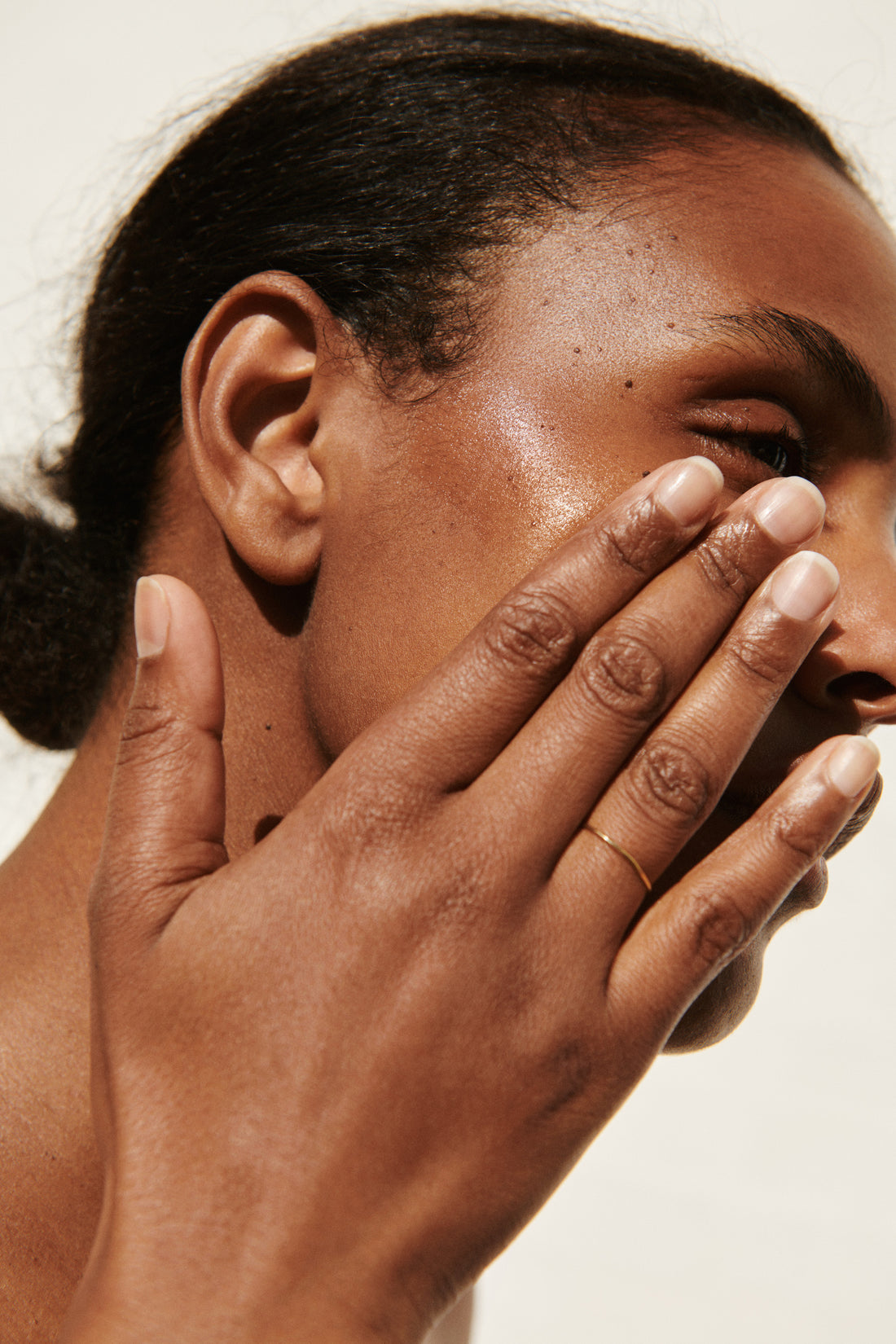 Woman putting natural fragrance-free face oil with botanical ingredients on her face